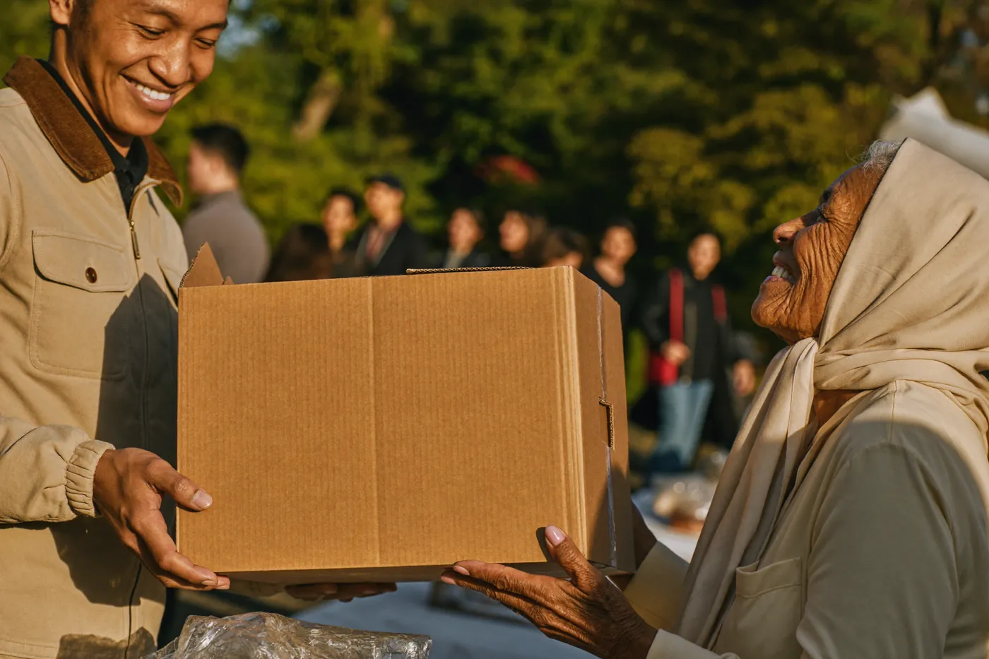 Food aid being handed to an elderly woman at a community distribution.